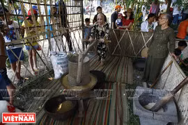 Người dân làng Thanh Toàn giới thiệu kỹ thuật xay lúa truyền thống tại phiên chợ qu. (Ảnh: Thanh Giang/Báo ảnh Việt Nam)