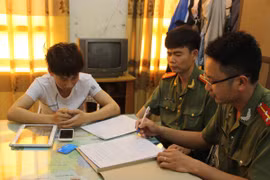 Đối tượng Bùi Đức Hải (áo trắng) bị triệu tập tại cơ quan Công an tỉnh Thái Bình. (Ảnh: Xuân Tiến/TTXVN)