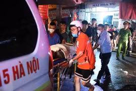 Lực lượng chức năng đưa các nạn nhân ra bên ngoài. (Ảnh: Phạm Kiên/TTXVN)