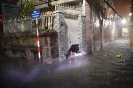 Người dân quận Thanh Khê (Đà Nẵng) dùng ván chắn không cho nước từ ngoài đường tràn vào nhà. (Ảnh: Trần Lê Lâm/TTXVN)