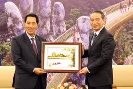 Bí thư Thành ủy Đà Nẵng Trương Quang Nghĩa tặng quà Phó Chủ tịch Quốc hội Lào Bounpone Bouttanavong. (Ảnh: Nguyễn Sơn/TTXVN)