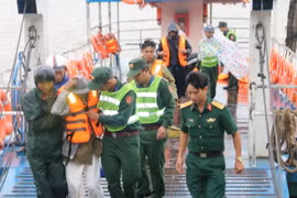 Lực lượng bộ đội tỉnh Trà Vinh hướng dẫn, giúp đỡ dân di tản về đất liền. (Ảnh: Phúc Sơn/TTXVN)