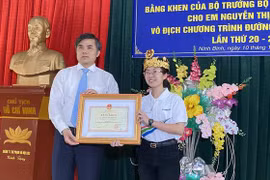 Ông Bùi Văn Linh, Vụ trưởng Vụ Giáo dục Chính trị và Công tác Học sinh sinh viên trao bằng khen cho em Thu Hằng. (Ảnh: PV)