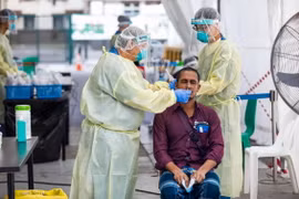 Nhân viên y tế lấy mẫu xét nghiệm COVID-19 cho người dân tại Singapore. (Ảnh: AFP/TTXVN)