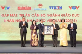 Ủy viên Trung ương Đảng, Tổng Biên tập Báo Nhân Dân, Chủ tịch Hội Nhà báo Việt Nam Lê Quốc Minh, đại diện lãnh đạo các cơ quan Thông tấn, báo chí tặng quà tri ân các nhà giáo. (Ảnh: Minh Quyết/TTXVN)