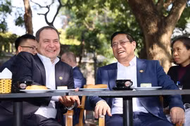 Thủ tướng Phạm Minh Chính và Thủ tướng Belarus Roman Golovchenko thưởng thức càphê trên phố Điện Biên Phủ, Hà Nội. (Ảnh: Dương Giang/TTXVN)