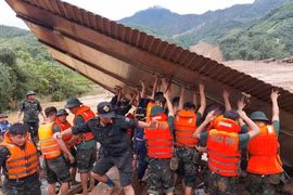 Các chiến sỹ thu dọn những ngôi nhà của nhân dân bị sập hoàn toàn sau trận lũ. (Ảnh: TTXVN phát)