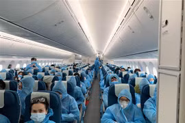 Tất cả hành khách được phát và phải mặc đồ bảo hộ trong suốt chuyến bay từ Vương quốc Anh về Việt Nam. (Ảnh: TTXVN phát)