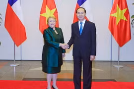 Chủ tịch nước Trần Đại Quang đón Tổng thống Michelle Bachelet Jeria. (Ảnh: Nhan Sáng/TTXVN)