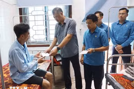Chủ nhiệm Ủy ban Kiểm tra Tổng Liên đoàn Lao động Việt Nam Nguyễn Minh Dũng trao hỗ trợ các công nhân bị tai nạn do sạt lở đất, khi thi công Dự án đường điện 500KV mạch 3, đoạn đi qua thị xã Kỳ Anh, Hà Tĩnh. (Ảnh: TTXVN)