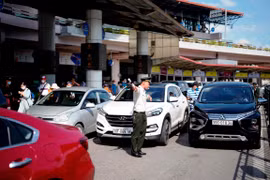 Lực lượng An ninh sân đỗ ôtô tăng cường điều tiết trong điều kiện nắng nóng, giữa dòng xe nối đuôi nhau từ sáng sớm đến đêm muộn. (Ảnh: CTV/Vietnam+)