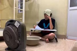 Để hạ nhiệt độ trong nhà trọ tránh nóng, sinh viên thuê phòng dùng đá lạnh bỏ vào chậu nước ngay dưới chân quạt để hơi gió phả ra đỡ nóng. (Ảnh: Bảo Anh/Vietnam+)