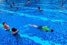 Thời gian gần đây, nhiều gia đình đã cho trẻ em đi học bơi trong đợt nghỉ Hè. (Ảnh: Bảo Anh/Vietnam+)