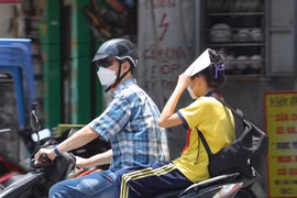 Người phải di chuyển dưới nắng nóng, nền nhiệt cao ngoài trời dễ gây nên tình trạng sốc nhiệt, mất nước, kiệt sức... (Ảnh: Hoàng Hiếu/TTXVN)