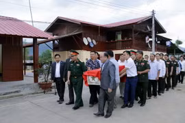 Các đại biểu hai nước rước hài cốt ''các anh'' lên đường trở về đất Mẹ. (Ảnh: Phạm Kiên/TTXVN)