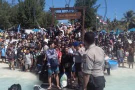 Hàng trăm khách du lịch chờ sơ tán khỏi Gili Trawangan, khu vực lân cận đảo Lombok, Indonesia, ngày 6/8. (Ảnh: AFP/TTXVN)