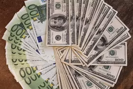 Tiền giấy mệnh giá 100 euro (trái) và 100 USD tại Paris, Pháp. (Ảnh: AFP/TTXVN)