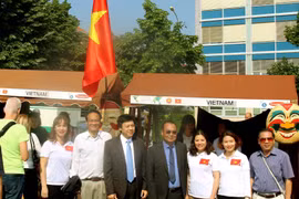 Đại sứ Việt Nam tại Sec Hồ Minh Tuấn (sơmi trắng, càvạt xanh) và các cán bộ Đại sứ quán tại quầy ẩm thực Việt Nam. (Ảnh: Trần Quang Vinh/TTXVN)