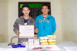 Hai đối tượng cùng tang vật tại cơ quan điều tra. (Ảnh: Xuân Tư/TTXVN)