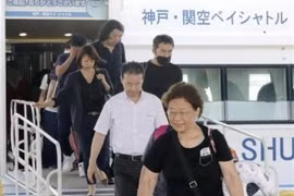 Hành khách di chuyển từ sân bay Kansai xuống xuồng cao tốc để sang sân bay Kobe ngày 5/9. (Ảnh: Kyodo/TTXVN)