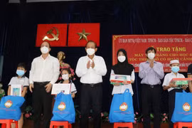 Ông Trương Hòa Bình cùng đại diện lãnh đạo TP Hồ Chí Minh và đơn vị tài trợ trao máy tính bảng và quà cho đại diện các em học sinh dân tộc thiểu số khó khăn trên địa bàn. (Ảnh: Xuân Khu/TTXVN)