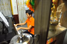 Võ Minh Quang luyện tập piano tại nhà. (Ảnh: Minh Đức/TTXVN)