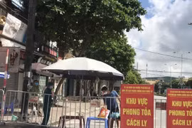 Người dân trong khu vực phong tỏa trên phố Ngô Quyền (Hải Dương) nhận thực phẩm tiếp tế tại hàng rào cách ly. (Ảnh: Mạnh Minh/TTXVN)