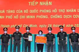 Bà Tô Thị Bích Châu, Chủ tịch Ủy ban Mặt trận Tổ quốc Việt Nam Thành phố Hồ Chí Minh tiếp nhận bảng tượng trưng quà tặng của Bộ Quốc phòng từ Trung tướng Ngô Minh Tiến. (Ảnh: TTXVN phát)