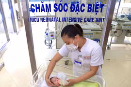 Nữ điều dưỡng Bệnh viện Trung ương Huế tận tình chăm sóc con của một sản phụ mắc COVID-19. (Ảnh: TTXVN phát)
