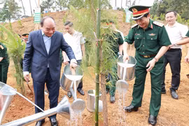 Chủ tịch nước Nguyễn Xuân Phúc cùng các đại biểu trồng cây tại Khu Di tích K9. (Ảnh: Thống Nhất/TTXVN)