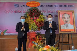 Bí thư Trung ương Đảng, Trưởng ban Tuyên giáo Trung ương Nguyễn Trọng Nghĩa tặng hoa chúc mừng thầy cô giáo Đại học Quốc gia Thành phố Hồ Chí Minh. (Ảnh: Thu Hoài/TTXVN)