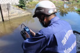 Công nhân vận hành cống kiểm tra độ mặn tại cống Kênh Lầu, xã Hỏa Tiến. (Ảnh: Hồng Thái/TTXVN)