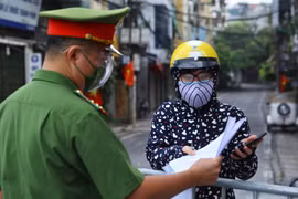 Công an kiểm tra giấy tờ đi đường của người dân phường Chương Dương khu vực được phép ra ngoài khi cần thiết (ảnh chụp sáng 17/8 tại cửa khẩu Cầu Đất). (Ảnh: Hoàng Hiếu/TTXVN) 