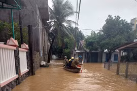Nhân viên EVNCPC chèo thuyền đi kiểm tra hệ thống điện tại các nơi ngập nước để nhanh chóng khôi phục các sự cố về điện tại các vùng ngập lũ. (Ảnh: TTXVN phát)