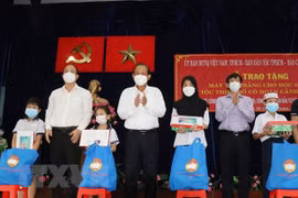 Ông Trương Hòa Bình, nguyên Ủy viên Bộ Chính trị, nguyên Phó Thủ tướng Thường trực Chính phủ, và ông Nguyễn Hồ Hải, Phó Bí thư Thành ủy Thành phố Hồ Chí Minh (thứ 2 từ trái sang) trao tặng máy tính bảng cho các học sinh dân tộc Chăm và Khmer. (Ảnh: Xuân K
