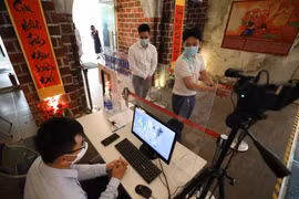 Khách tham quan di sản Hoàng thành Thăng Long được đo thân nhiệt, sát khuẩn tay đầy đủ. (Ảnh: Thanh Tùng/TTXVN)
