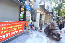 Tổ phòng, chống COVID cộng đồng thuộc tổ dân phố số 5, phường Bạch Mai, quận Hai Bà Trưng kiểm soát người dân ra, vào ngõ 29 Hồng Mai (ảnh chụp sáng 3/8). (Ảnh: Hoàng Hiếu/TTXVN) 