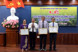 Chủ tịch Ủy ban Nhân dân tỉnh Sóc Trăng tặng bằng khen cho nhóm lai tạo giống lúa. Ảnh: Trung Hiếu/TTXVN)