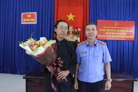 Đại diện Viện Kiểm sát nhân dân thành phố Nha Trang tặng hoa cho ông Thái Xuân Đàn trong buổi xin lỗi sáng 24/12. (Ảnh: Nguyễn Dũng/TTXVN)