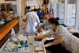 Các công nhân Công ty trách nhiệm hữu hạn Ấn Độ Dương, Cần Thơ nhập viện điều trị tại Bệnh viện Đa khoa Trung tâm An Giang do bị ngộ độc thực phẩm. (Ảnh: Thanh Sang/TTXVN)