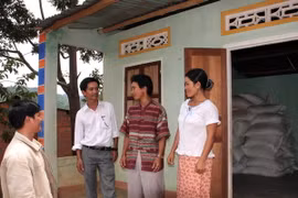 Cán bộ xã tuyên truyền, vận động người dân tích trữ lương thực nhằm phòng chống thiếu lương thực khi bị mưa lũ. (Ảnh: Trần Lê Lâm/TTXVN)