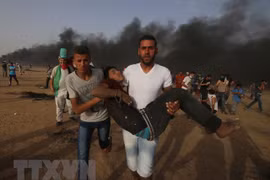 Chuyển nạn nhân bị thương trong cuộc xung đột giữa người biểu tình Palestine và binh sĩ Israel tại biên giới Gaza-Israel ngày 25/5. (Nguồn: THX/TTXVN)