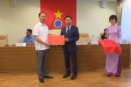 Đại sứ Ngô Đức Mạnh (bên phải) trao 3000 USD tiền quyên góp ủng hộ bà con bị thiệt hại trong vụ cháy trung tâm thương mại. (Ảnh: Trí Dương/Vietnam+)