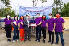 Lãnh đạo Báo Điện tử VietnamPlus trao tặng bình nước cho lãnh đạo xã Phố Cáo. (Ảnh: Minh Sơn/Vietnam+)