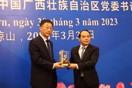Bí thư Tỉnh ủy Lạng Sơn Nguyễn Quốc Đoàn (phải) và Bí thư Khu ủy Khu tự trị dân tộc Choang Quảng Tây Lưu Ninh trao quà lưu niệm. (Ảnh: Quang Duy/TTXVN)