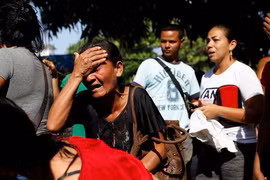 Thân nhân những người thiệt mạng bên ngoài đồn cảnh sát ở thành phố Valencia. (Nguồn: Reuters)