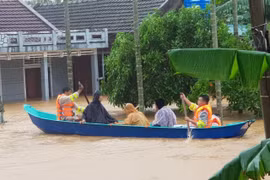 Di chuyển người dân ra khỏi khu vực ngập lũ tại huyện Cam Lộ, Quảng Trị. (Ảnh: Thanh Thủy/TTXVN)