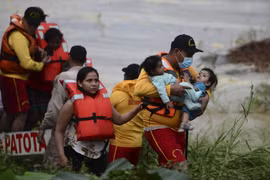 Sơ tán người dân khỏi các khu vực ngập lụt do mưa lớn sau bão Eta tại El Progreso, Honduras. (Ảnh: AFP/TTXVN)