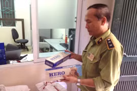 Cán bộ Đội Quản lý thị trường số 5 đang kiểm tra số thuốc lá ngoại nhập lậu bị tịch thu trên xe khách 74B-00.075 (Ảnh: Đức Duy/Vietnam+)