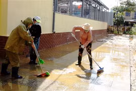 Dọn bùn đất sau lũ. (Ảnh: Võ Dung/TTXVN)